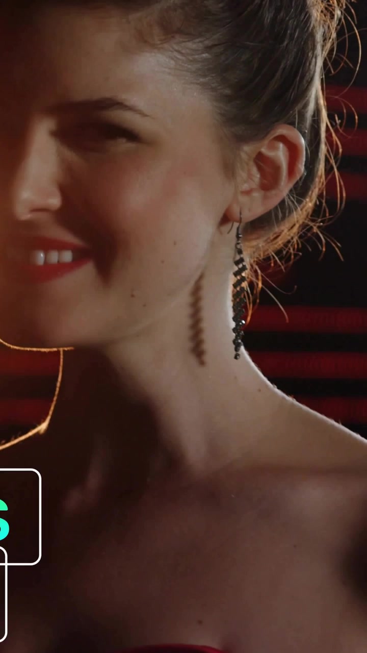 Video verticale: Donna che sorseggia da un calice, con icone verdi scintillanti in sovrimpressione e la telecamera che si allontana, festa.