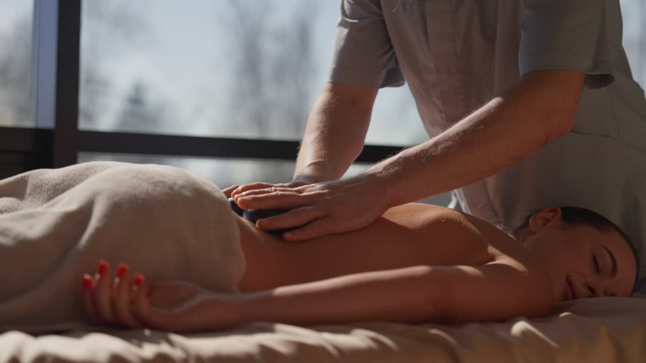 Kvinde modtager hot stone massage til afslapning på et spa
