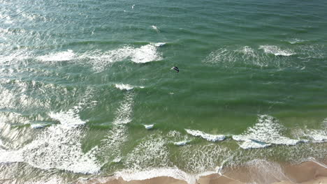 Antenne:-Drohnenblick-Auf-Das-Meer-Und-Menschen,-Die-Extremsport-Betreiben,-Kitesurfen