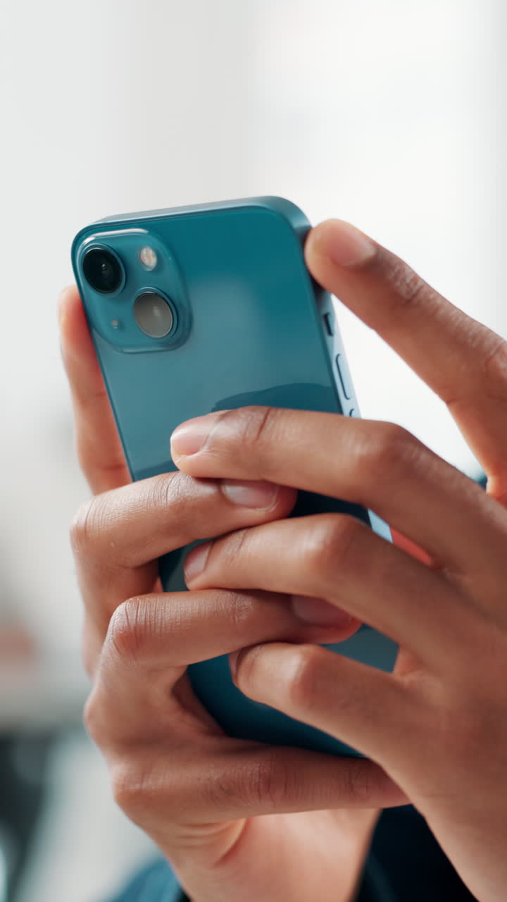 Primo piano di mani che reggono e utilizzano uno smartphone blu