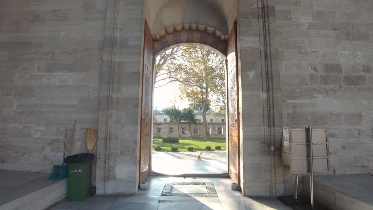 터키 이스탄불에 있는 유서 깊은 술레이마니예 모스크의 안뜰로 가는 웅장한 아치형 통로 입구를 통해 여행