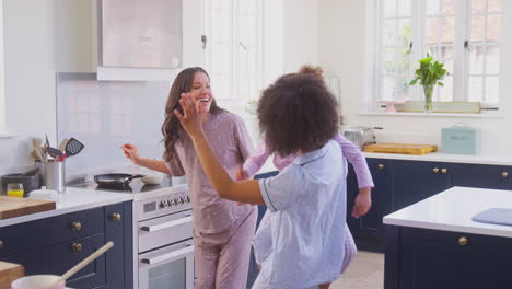 Familia-Embarazada-Con-Dos-Mamás-Bailando-Haciendo-Panqueques-Matutinos-En-La-Cocina-Con-Su-Hija