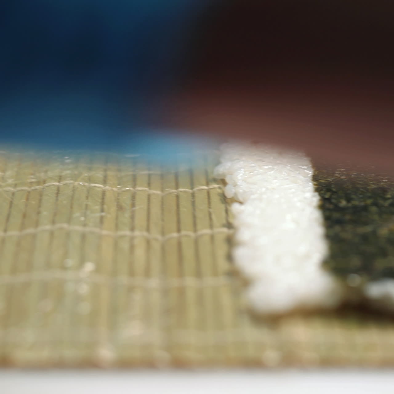 Hands make long sushi roll. Rice with pieces of fish. Sushi chef demonstrating skill. Famous japanese dish. Sqare video