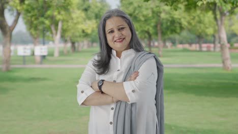 Portrait-of-Happy-Indian-mother-standing-crossed-hands-in-park