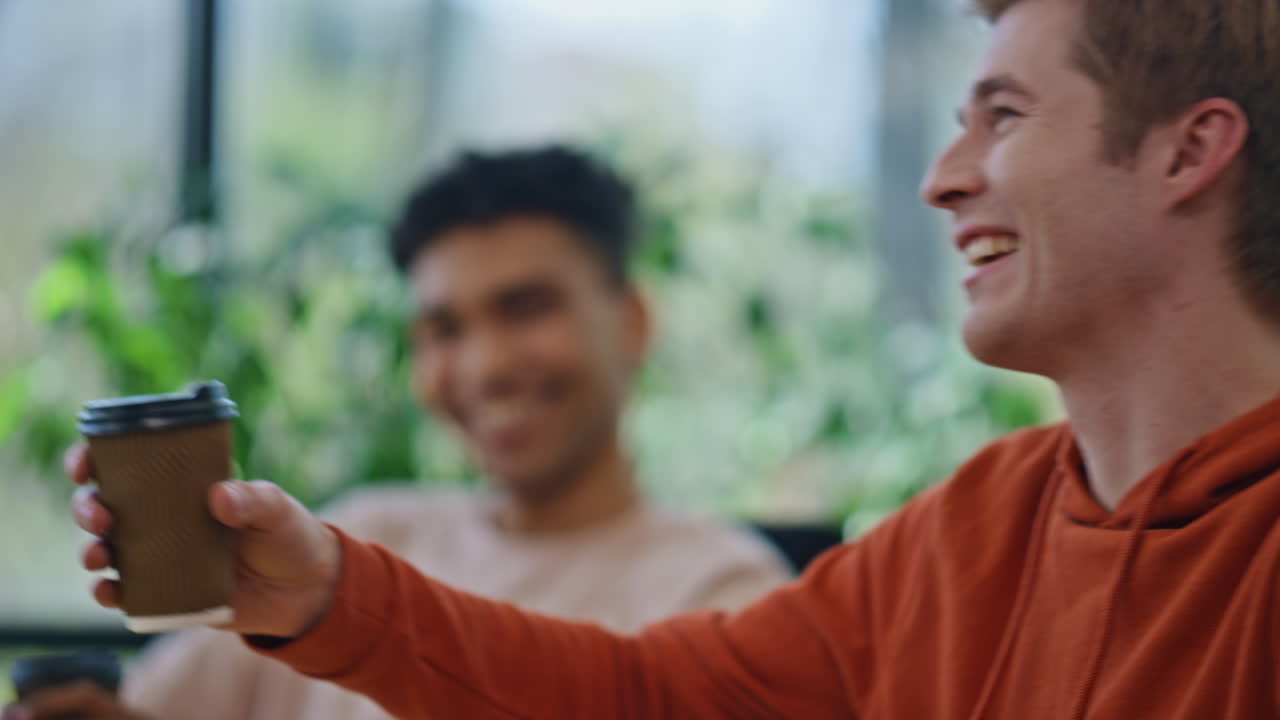 오피스맨이 웃으며 캐비 클로즈업에서 휴식을 취합니다. 다양한 행복한 팀 대화