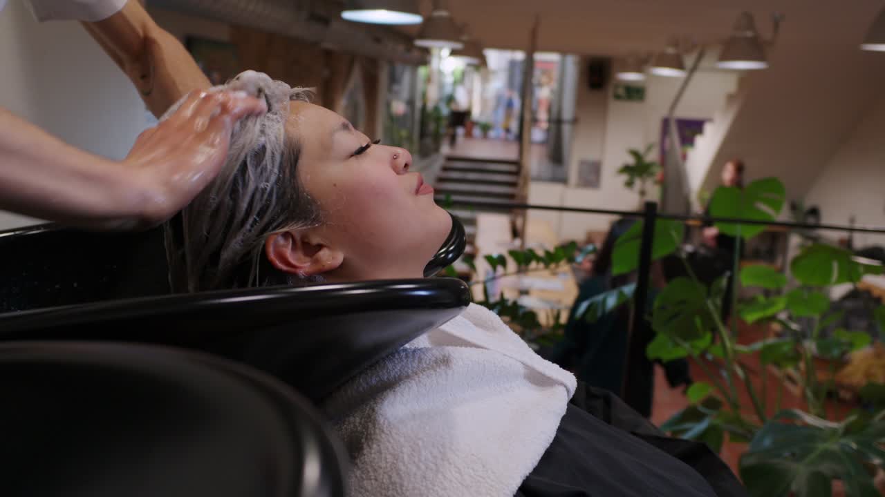 여자 가 헤어 살롱 에서 머리 를 고 있다