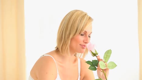 Blondhaired-woman-smelling-a-rose