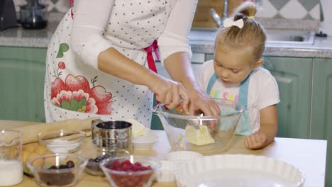 Mutter-Bringt-Ihrer-Kleinen-Tochter-Das-Backen-Bei