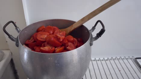 aluminum pot full of boiling fresh tomatoes for preparation of home made tomato sauce