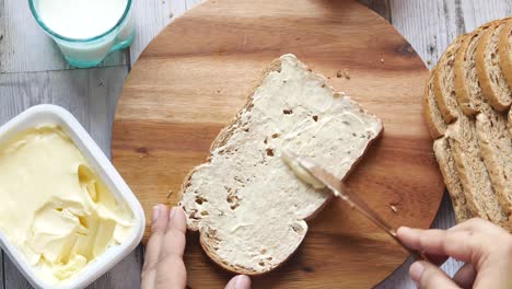 preparing a slice of bread with butter