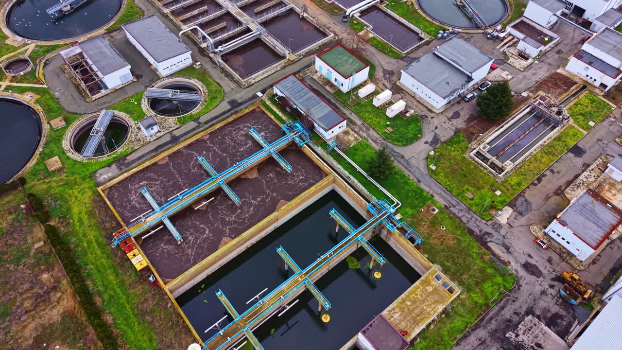 Water treatment facility showcases various stages of water purification process in an urban area during daylight hours