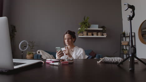 young cute vlogger woman taking a look at her smartphone