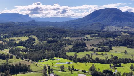 Aerial footage captures Nimbin's lush landscape with vibrant greenery and distant mountains under a bright sky