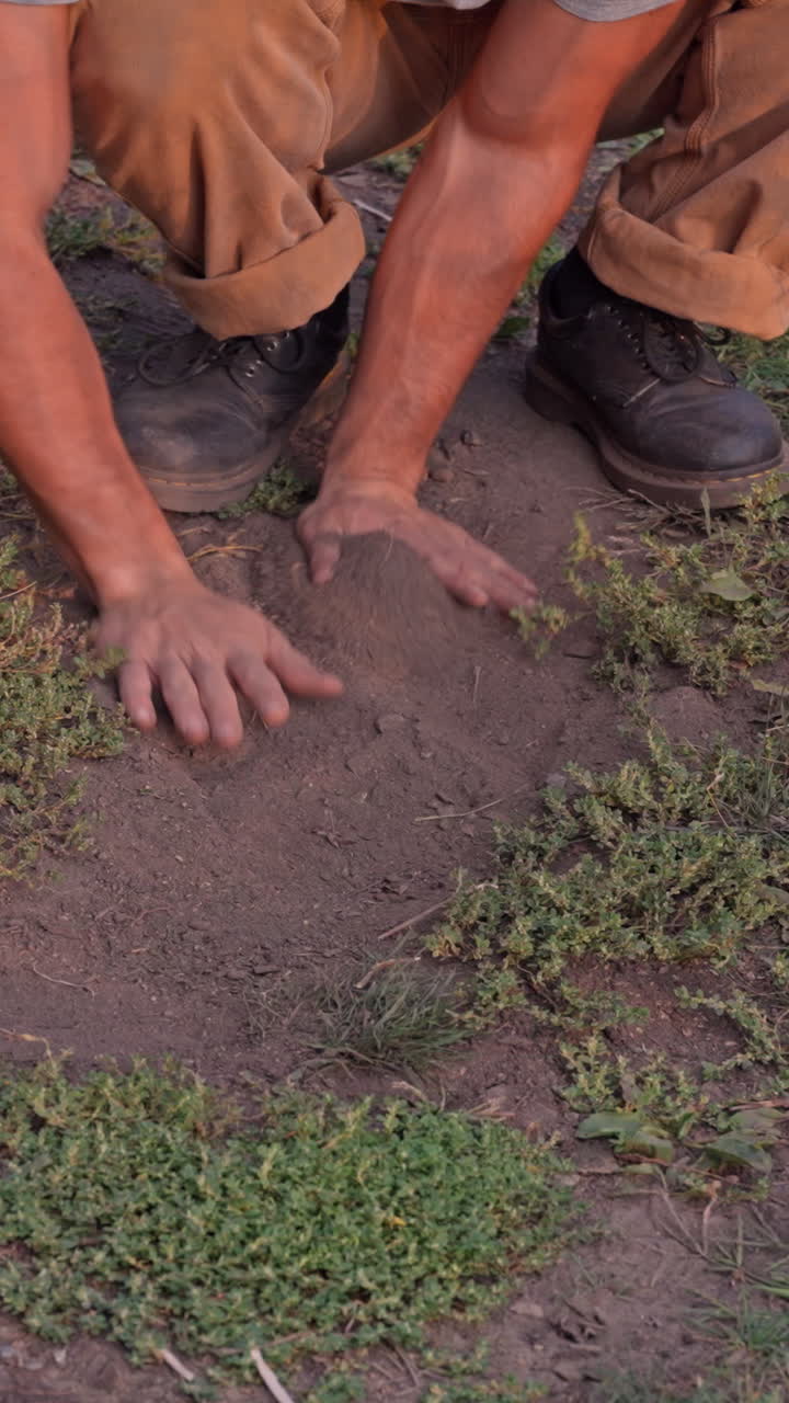 Close-up das mãos de um jovem enterrando um smartphone na terra, simbolizando o detox digital, a desconexão e a libertação da tecnologia em um ambiente natural. Close cinematográfico vertical