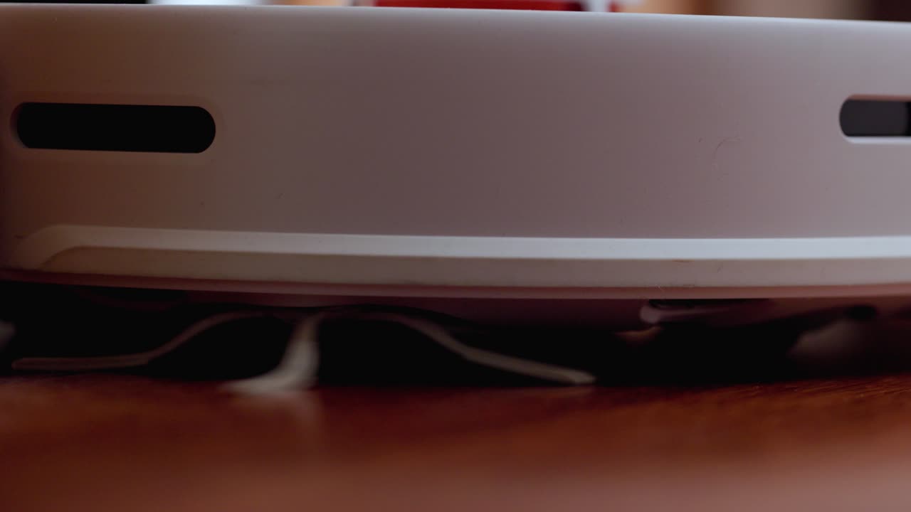 robot aspirador inteligente con lidar en el suelo de madera. robot aspirador realiza la limpieza automática del apartamento. 4k cámara lenta 100 fps, prores 422, 10 bits