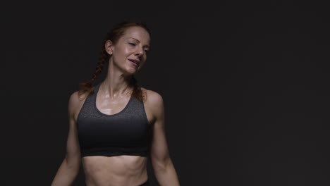 studio shot of mature woman wearing gym fitness clothing doing stretching exercises