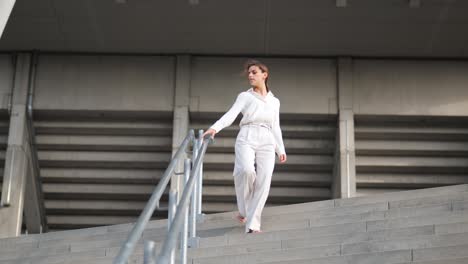 A-attractive-businesswoman-is-walking-down-the-stairs