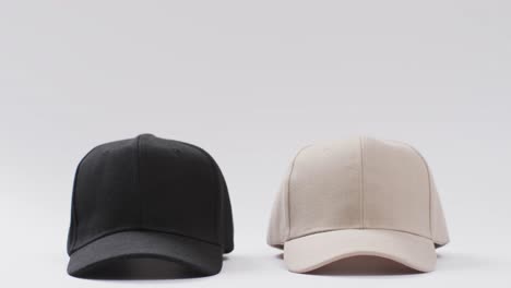 video de gorras de béisbol negras y beige y espacio de copia sobre fondo blanco