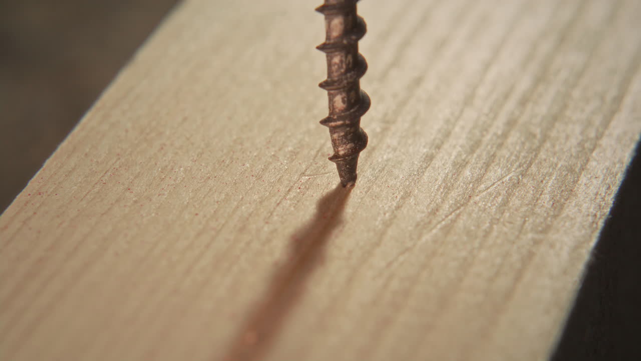 Close Up of Screw Being Inserted into Wooden Plank with Drill Driver Bit