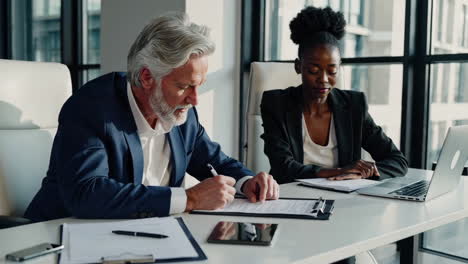 business professionals collaborating on documents in a modern office