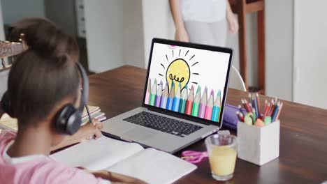 Composition-of-african-american-schoolgirl-on-laptop-online-learning-and-crayons