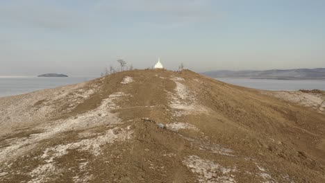 winter lake baikal with approach to the ritual buddhist stupa of enlightenment.