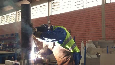 worker welding a metal peace in an industrial space