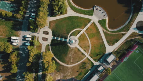 vista aérea de un parque con un estanque y un campo deportivo