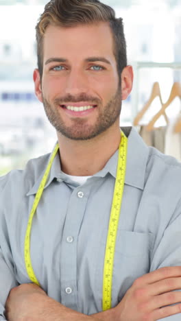 handsome fashion designer smiling at camera with arms crossed