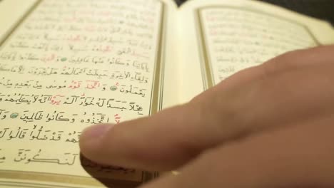 hands turning the pages of the quran reading and browsing the book