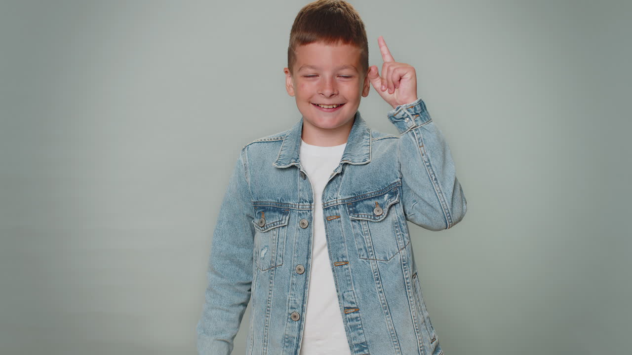 вдохновленный молодой мальчик указывает пальцем вверх, показывая жест эврики, решение, идея, вдохновение, ответ