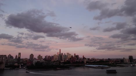 Aerial-view-of-a-Helicopter-flying-over-the-Brooklyn-cityscape,-dusk-in-NYC,-USA---Pan,-drone-shot