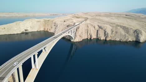 connecting with elegant bridge island pag, white stone and deep hues of blue adriatic, drone landing aerial