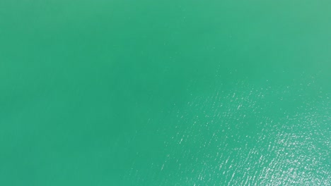 top down view of turquoise water of the ocean - aerial drone shot