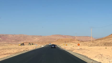 Dash-camera-point-of-view-driving-through-desert-and-arid-landscape