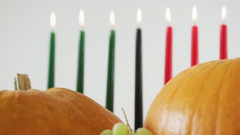 Composition-of-seven-lit-candles-and-halloween-pumpkins