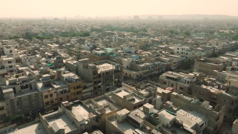 Aerial-drone-backward-moving-shot-over-congested-city-of-Ancholi-with-rows-of-buildings-in-the-Karachi,-Pakistan-at-daytime