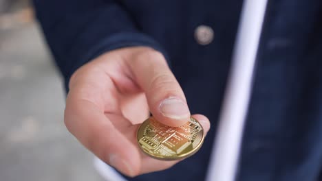 bitcoin on a white caucasian hand