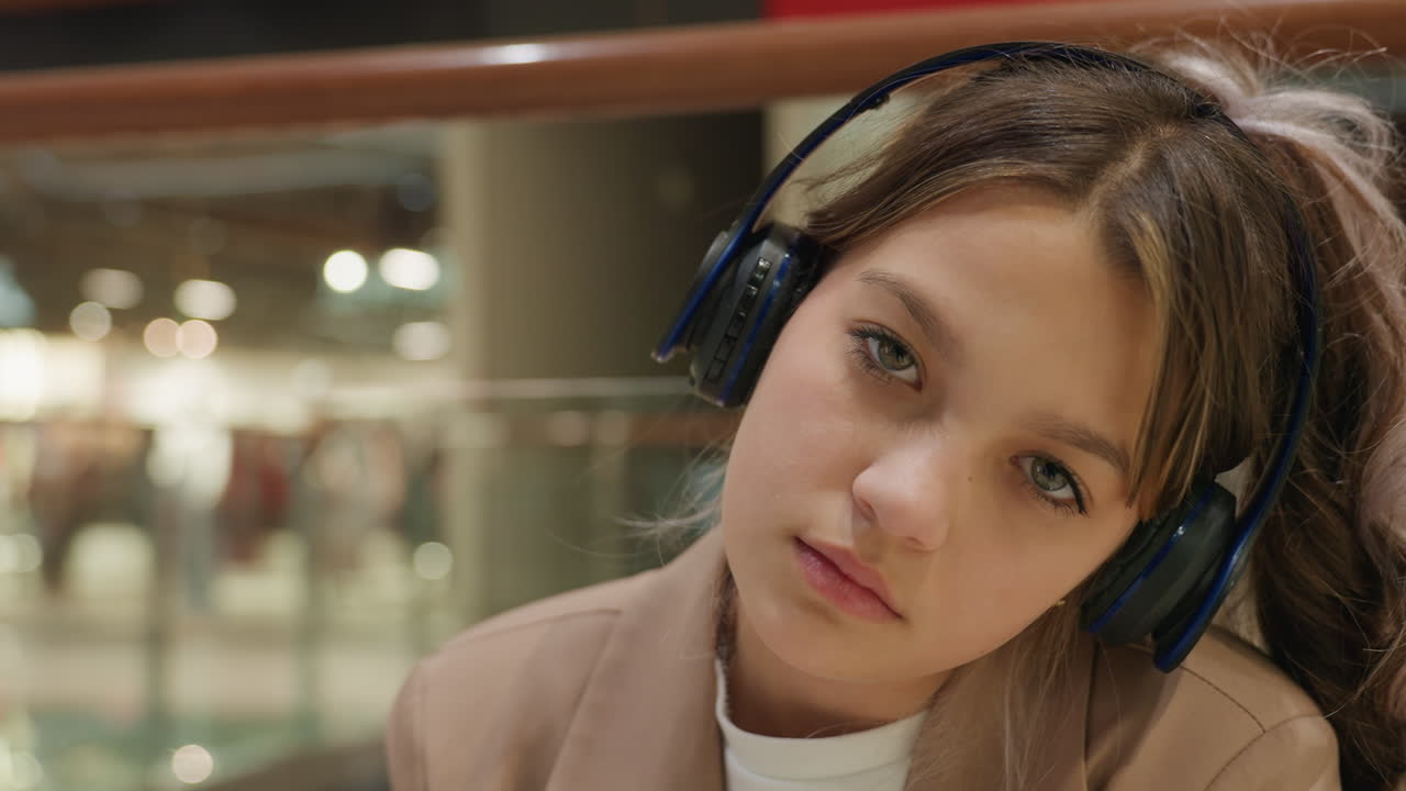젊음이 느껴지는 시선, 10대가 집중해서 친밀하게 듣고 있는 장면, 음악 분위기에 몰입한 젊은이의 클로즈업, 소매점에서 헤드폰을 끼고 감정적으로 몰입하고 있는 젊은이