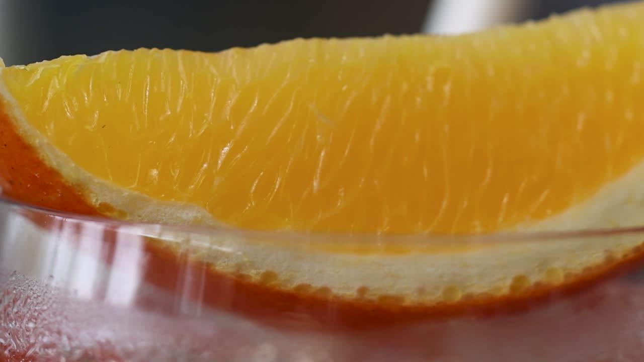 Close-up of a chilled Aperol Spritz with an orange slice garnish, highlighting condensation and vibrant colors