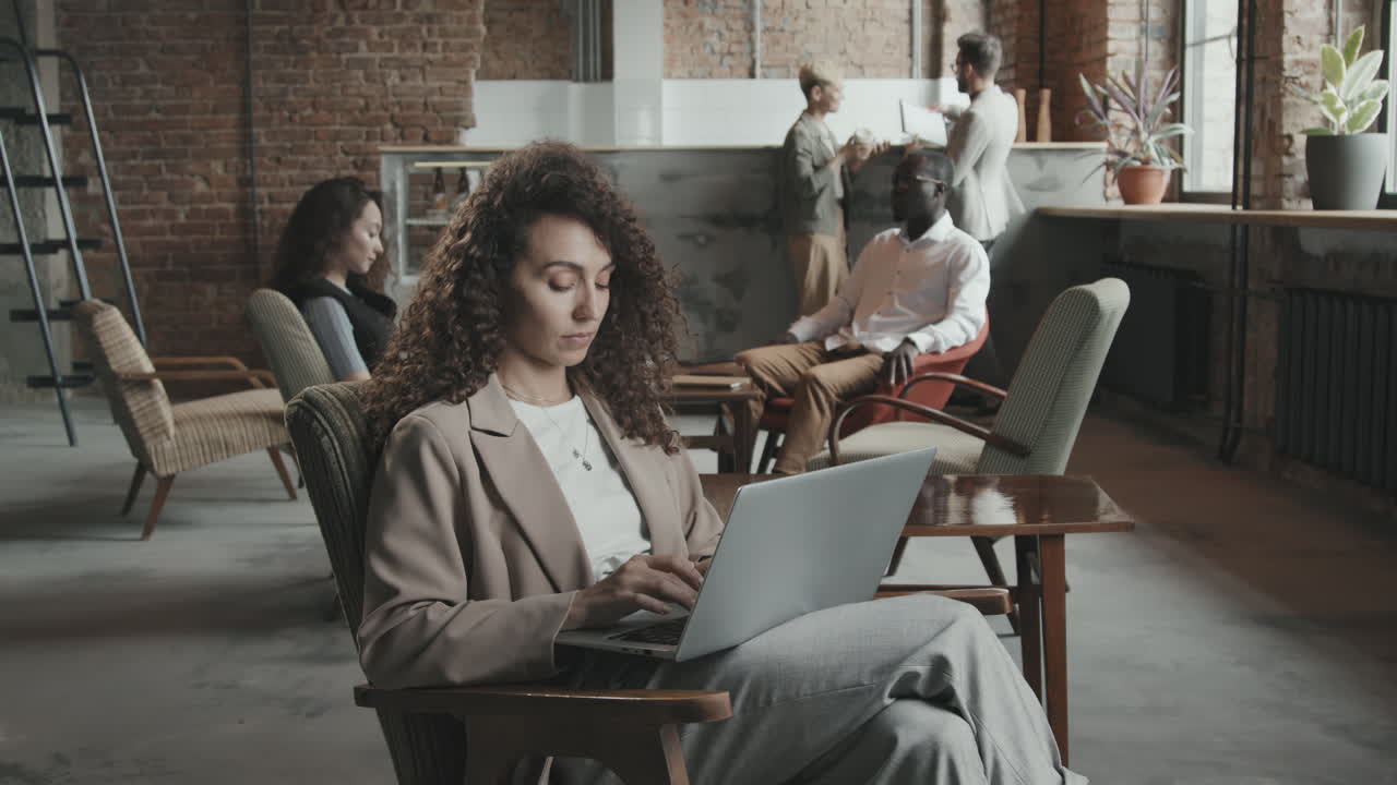 Young Businesswoman Working on Laptop in Coworking Office