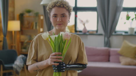 portrait of pretty girl with prosthetic arm holding flower bouquet