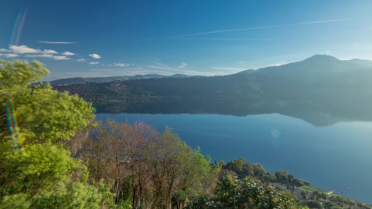 Pemandangan panorama pantai Danau Albano saat matahari terbit timelapse, Provinsi Roma, Lazio, Italia tengah. Pohon hijau di pagi hari.