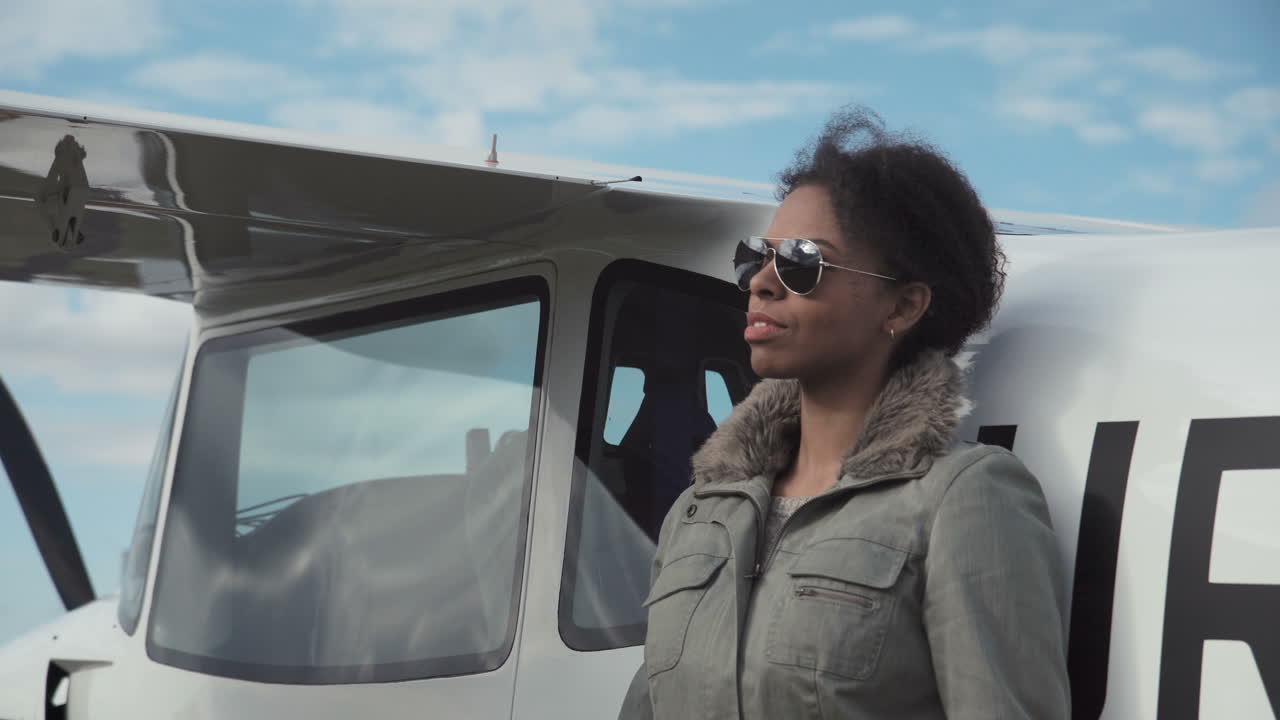 Female pilot by small plane