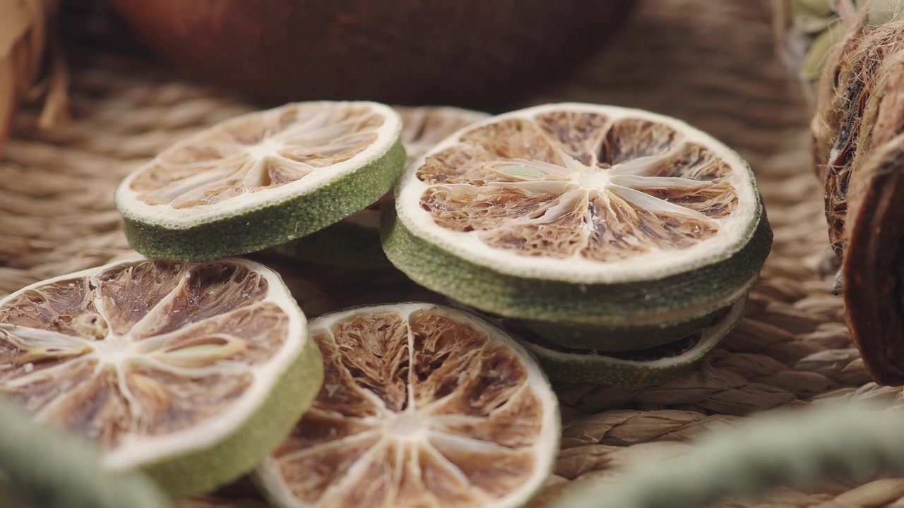 Fette di lime essiccate disposte su una superficie intrecciata
