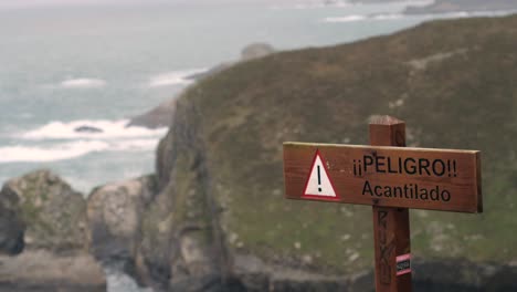 warning sign in spanish reading: danger, cliff