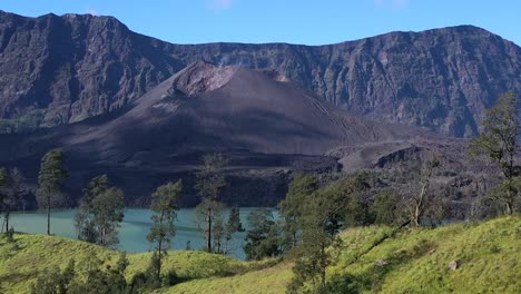 active mount rinjani volcano in indonesia with eroded walls panoramic, aerial dolly left shot