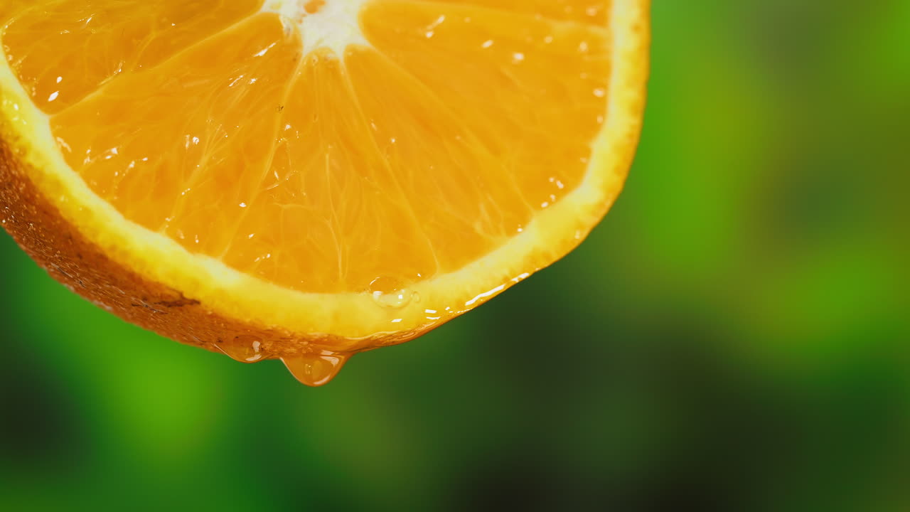 Primo piano di una fetta d'arancia fresca con succo che cola