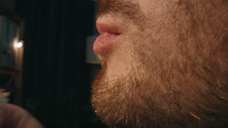 Man-mouth-biting-dinner-at-home-closeup.-Guy-eating-appetizing-sandwich-at-night