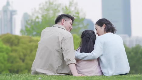 happy family in the outdoor outing having a picnic in the park, concept of destination, family travel and summer vacation or holidays